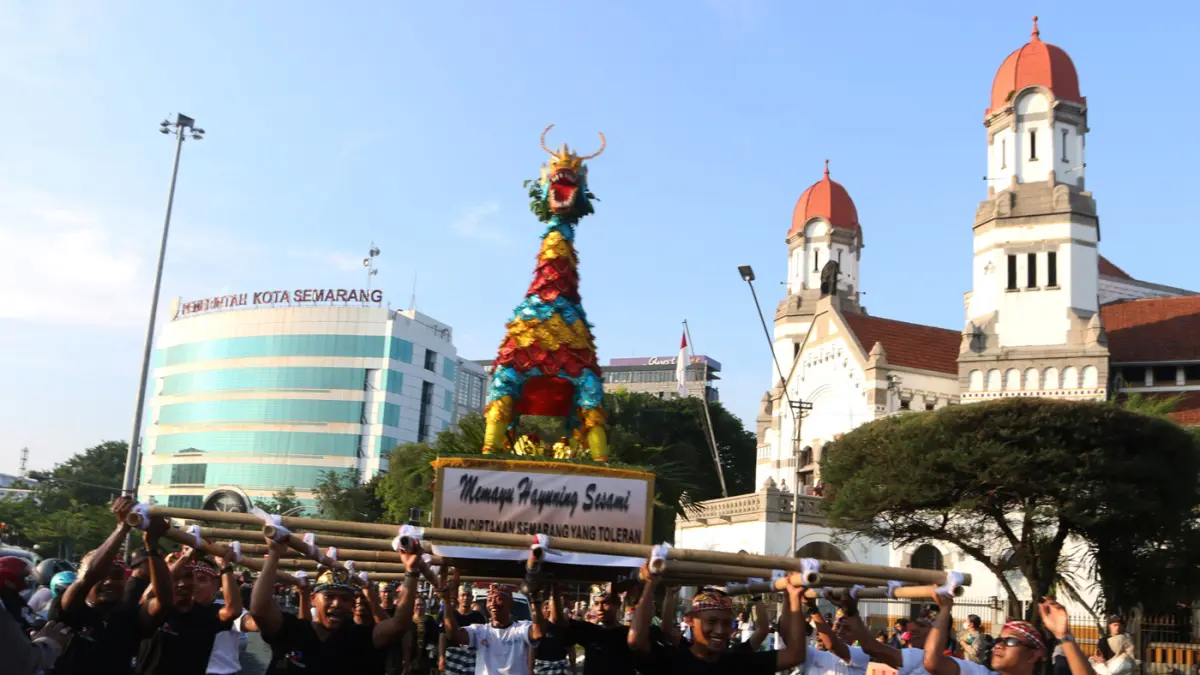 Warga menyambut kemeriahan Karnaval Seni Budaya Lintas Agama atau Pawai Ogoh-ogoh melintas di lawang sewu Kota Semarang (26/4/2026). (Nur Chamim/Jawa Pos Radar Semarang)
