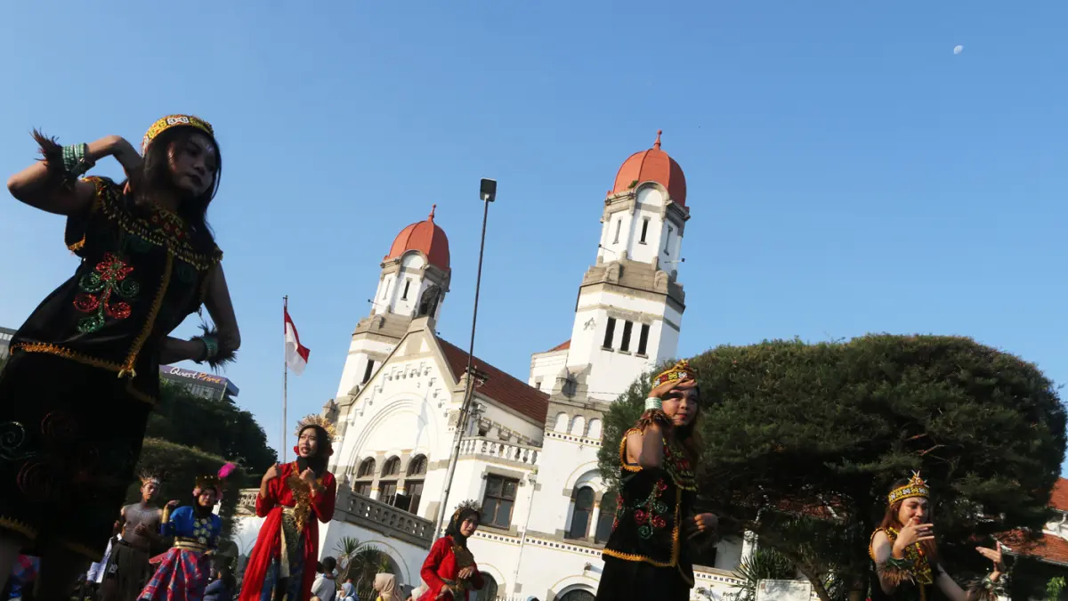 Warga menyambut kemeriahan Karnaval Seni Budaya Lintas Agama atau Pawai Ogoh-ogoh melintas di lawang sewu Kota Semarang (26/4/2026). (Nur Chamim/Jawa Pos Radar Semarang)