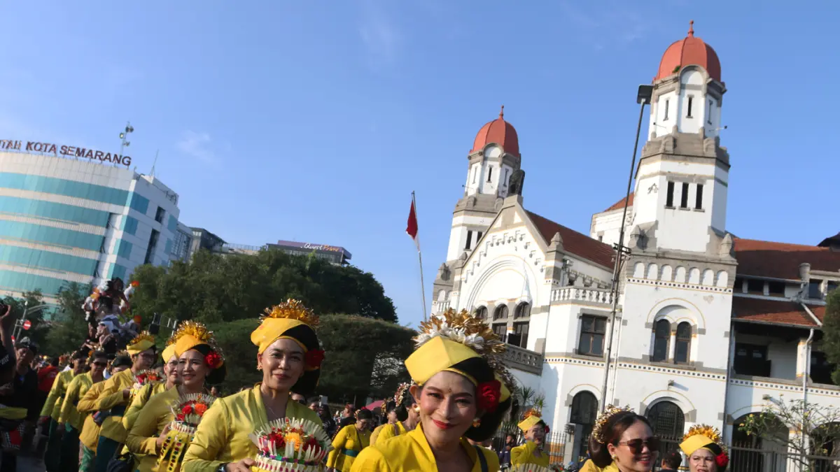 Warga menyambut kemeriahan Karnaval Seni Budaya Lintas Agama atau Pawai Ogoh-ogoh melintas di lawang sewu Kota Semarang (26/4/2026). (Nur Chamim/Jawa Pos Radar Semarang)