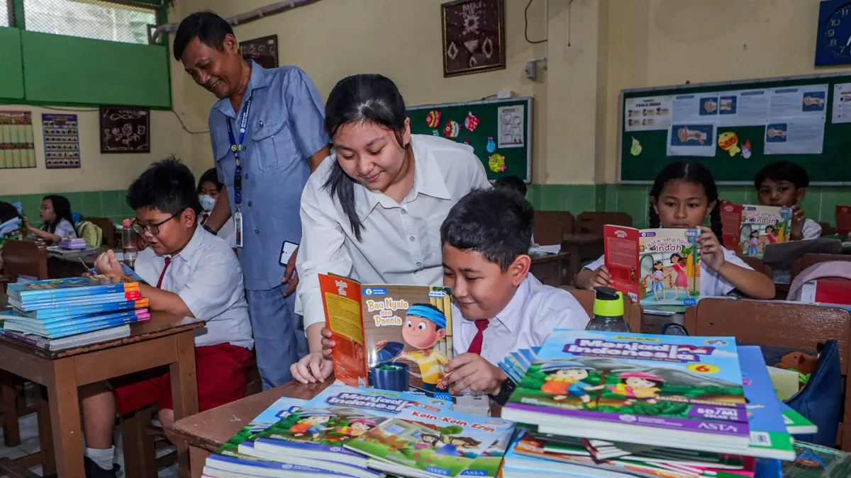 Caitlin Gabrielle Alim membagikan buku dalam kampanye Sejuta Buku di SDK St. Vincentius 1, kemarin (27/4). (Riana Setiawan/Jawa Pos)