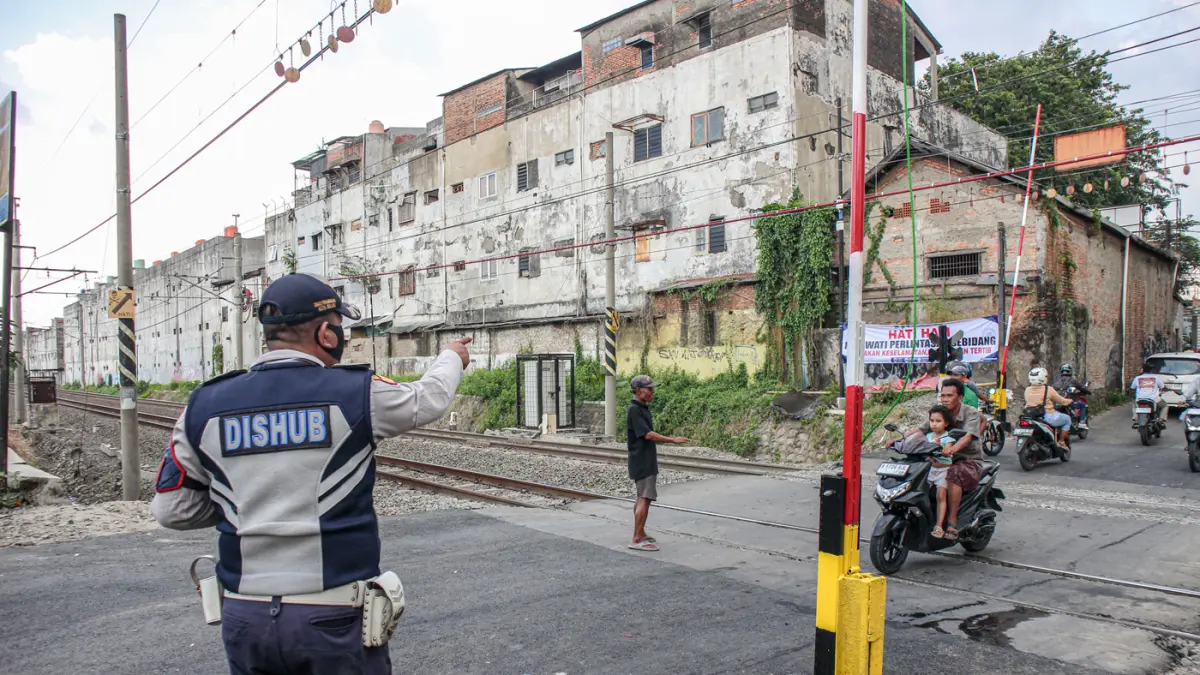 Suasana lalu lintas yang dijaga oleh petugas Dinas Perhubungan (Dishub) Kota Bekasi setelah pemasangan palang pintu di perlintasan sebidang di Jalan Ampera, Kota Bekasi, Sabtu (02/05/2026). Suasana lalu lintas yang dijaga oleh petugas Dinas Perhubungan (D