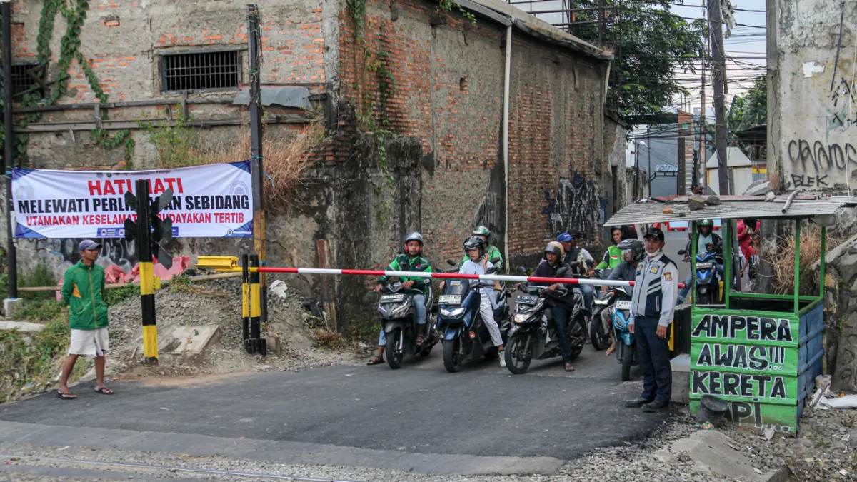 Suasana lalu lintas yang dijaga oleh petugas Dinas Perhubungan (Dishub) Kota Bekasi setelah pemasangan palang pintu di perlintasan sebidang di Jalan Ampera, Kota Bekasi, Sabtu (02/05/2026). Suasana lalu lintas yang dijaga oleh petugas Dinas Perhubungan (D