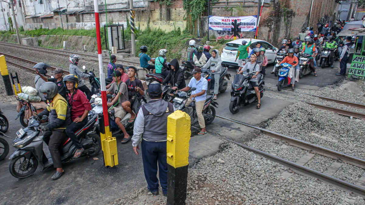 Suasana lalu lintas yang dijaga oleh petugas Dinas Perhubungan (Dishub) Kota Bekasi setelah pemasangan palang pintu di perlintasan sebidang di Jalan Ampera, Kota Bekasi, Sabtu (02/05/2026). Suasana lalu lintas yang dijaga oleh petugas Dinas Perhubungan (D