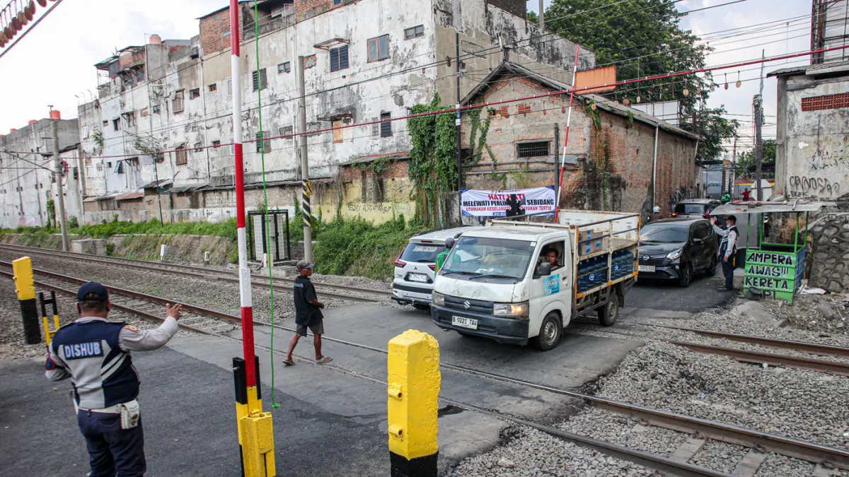Suasana lalu lintas yang dijaga oleh petugas Dinas Perhubungan (Dishub) Kota Bekasi setelah pemasangan palang pintu di perlintasan sebidang di Jalan Ampera, Kota Bekasi, Sabtu (02/05/2026). Suasana lalu lintas yang dijaga oleh petugas Dinas Perhubungan (D