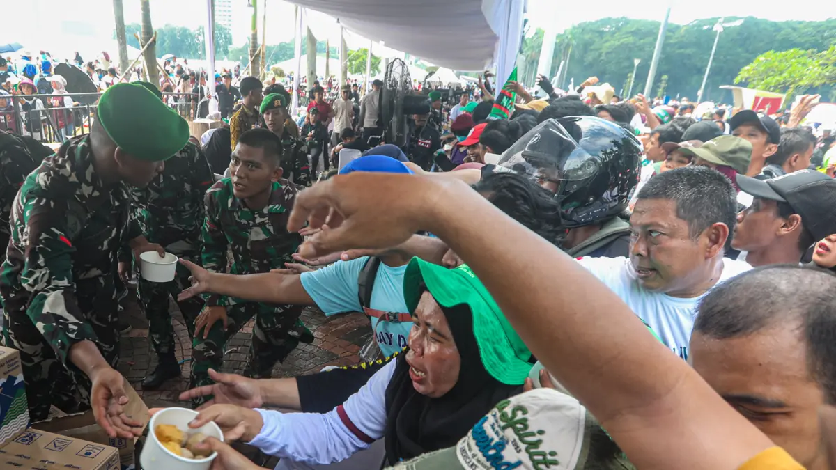 Petugas membagikan makanan gratis kepada masa buruh saat peringatan Hari Buruh Internasional atau May Day 2026 di kawasan Monumen Nasional (Monas), Jakarta, Jumat (1/5/2026). (Salman Toyibi/Jawa Pos)