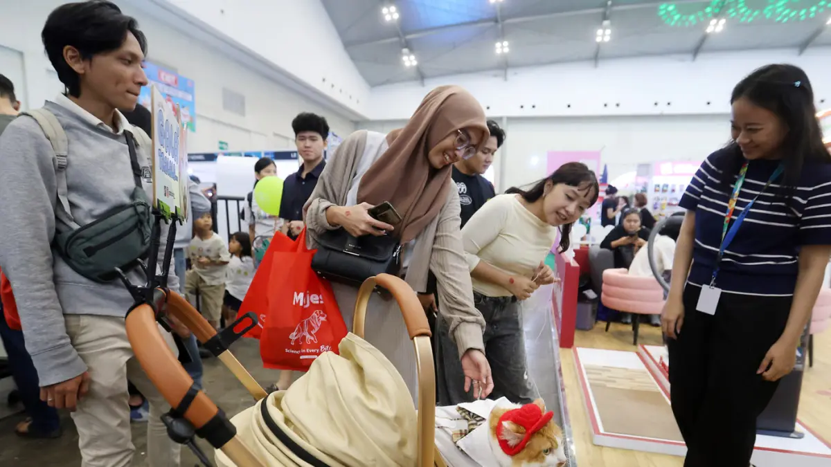 Petugas membantu pengunjung mencari promo di Travel Fair 2026 di Mal Gandaria City, Jakarta, Jumat (1/5/2026).