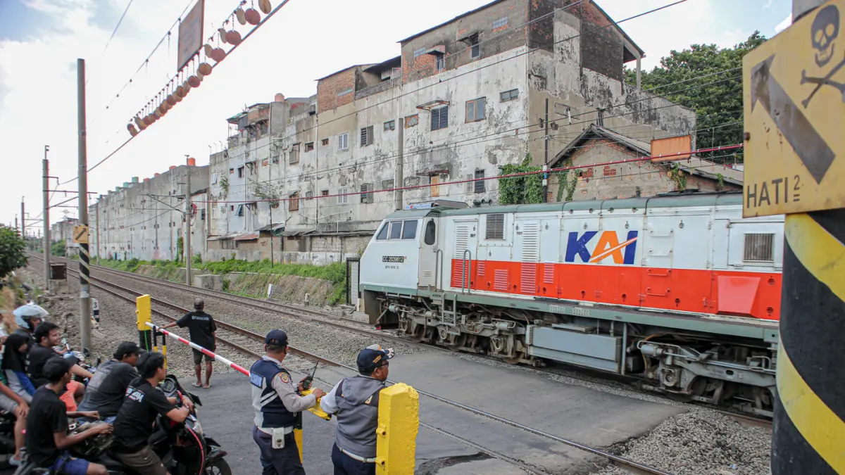 Suasana lalu lintas yang dijaga oleh petugas Dinas Perhubungan (Dishub) Kota Bekasi setelah pemasangan palang pintu di perlintasan sebidang di Jalan Ampera, Kota Bekasi, Sabtu (02/05/2026). (Hanung Hambara/Jawa Pos)