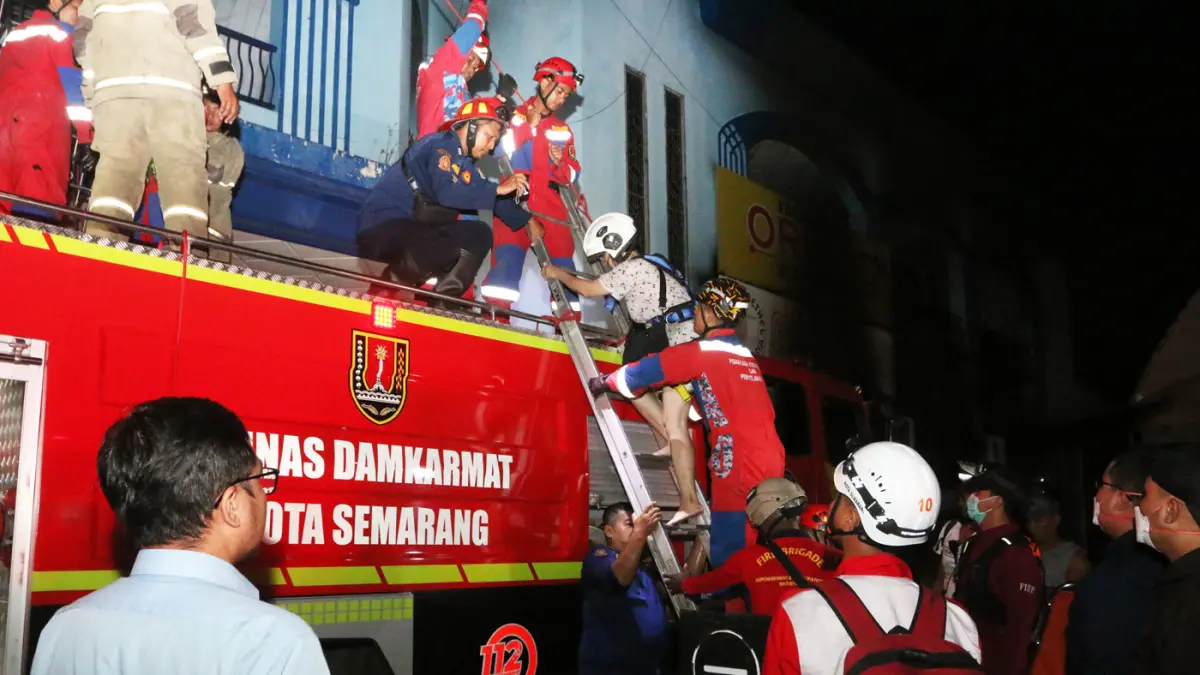 Petugas pemadam kebakaran mengevakuasi warga yang terjebak saat kebakaran melanda Gedung Metro Sport Center, di Semarang, Jawa Tengah, Senin (4/5/2026). (Nur Chamim/Jawapos Radar Semarang)