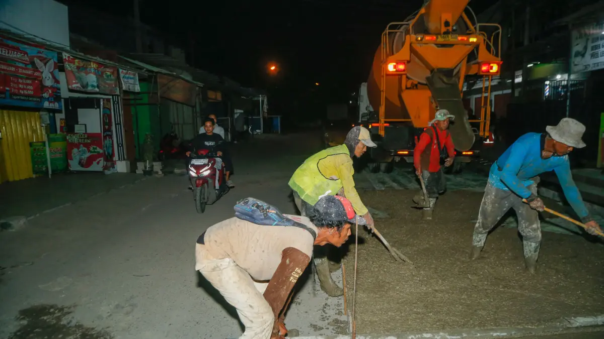 Pekerja menyelesaikan pengerjaan perbaikan jalan di Puri Cendana, Tambun Selatan, Kabupaten Bekasi, Minggu (3/5/2026).