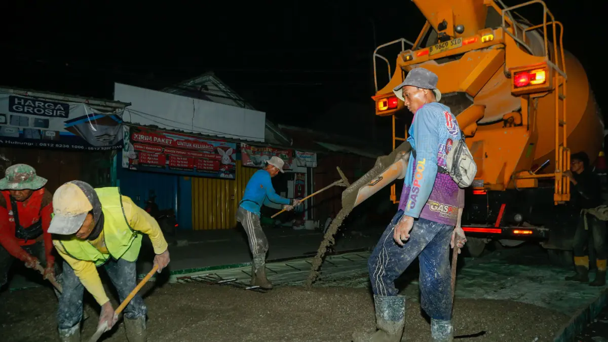 Pekerja menyelesaikan pengerjaan perbaikan jalan di Puri Cendana, Tambun Selatan, Kabupaten Bekasi, Minggu (3/5/2026).