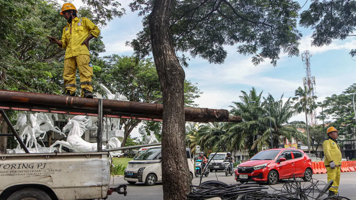 Sejumlah petugas dari Suku Dinas Bina Marga Jakarta Barat membersihkan potongan kabel utilitas di Jalan Peta Barat, Jakarta, Selasa (05/05/2026). (Hanung Hambara/Jawa Pos)