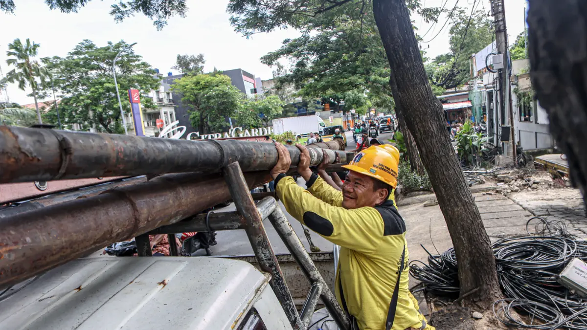 Sejumlah petugas dari Suku Dinas Bina Marga Jakarta Barat membersihkan potongan kabel utilitas di Jalan Peta Barat, Jakarta, Selasa (05/05/2026). (Hanung Hambara/Jawa Pos)
