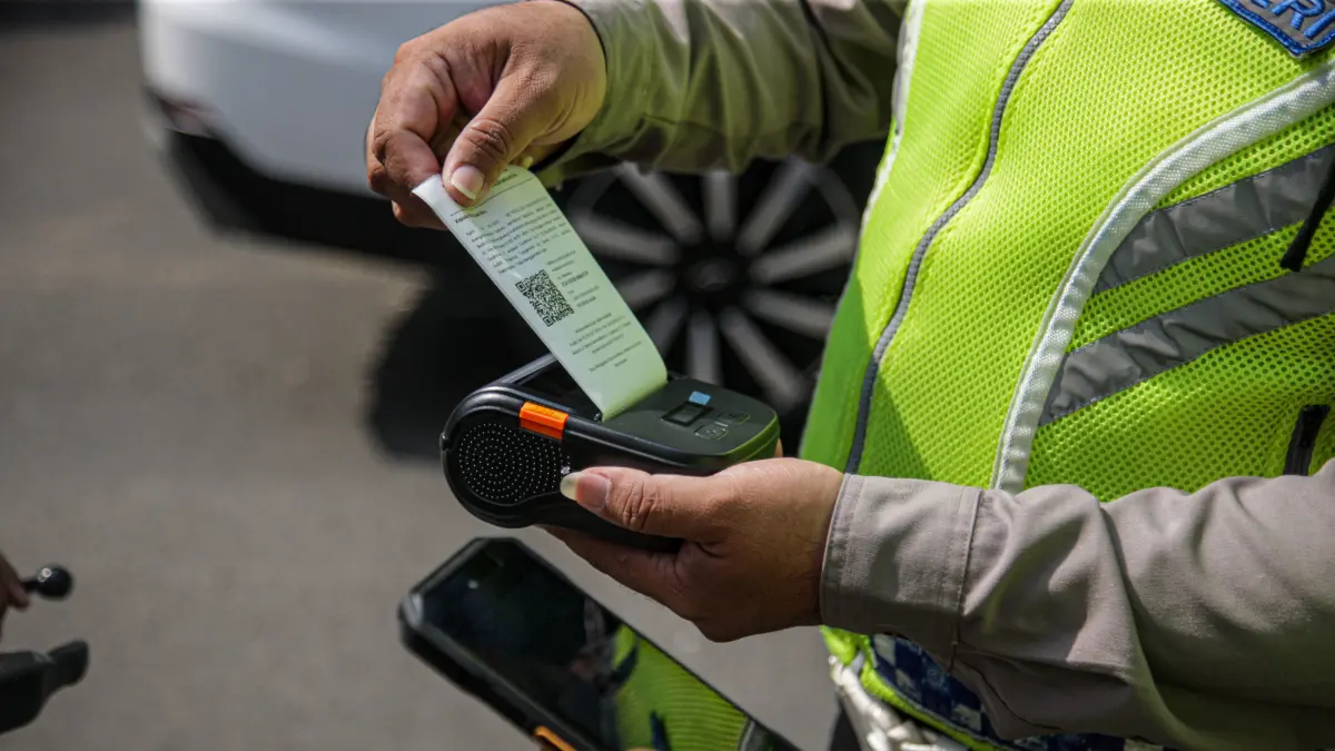 Anggota Satlantas Polres Metro Tangerang Kota melakukan pendindakan pengendaran yang tidak memakai helm dengan tilang ETLE Handheld di jalan Daan Mogot, Kota Tangerang, Kamis (07/05/2025). Tilang ETLE Handheld adalah sistem tilang elektronik portabel berb