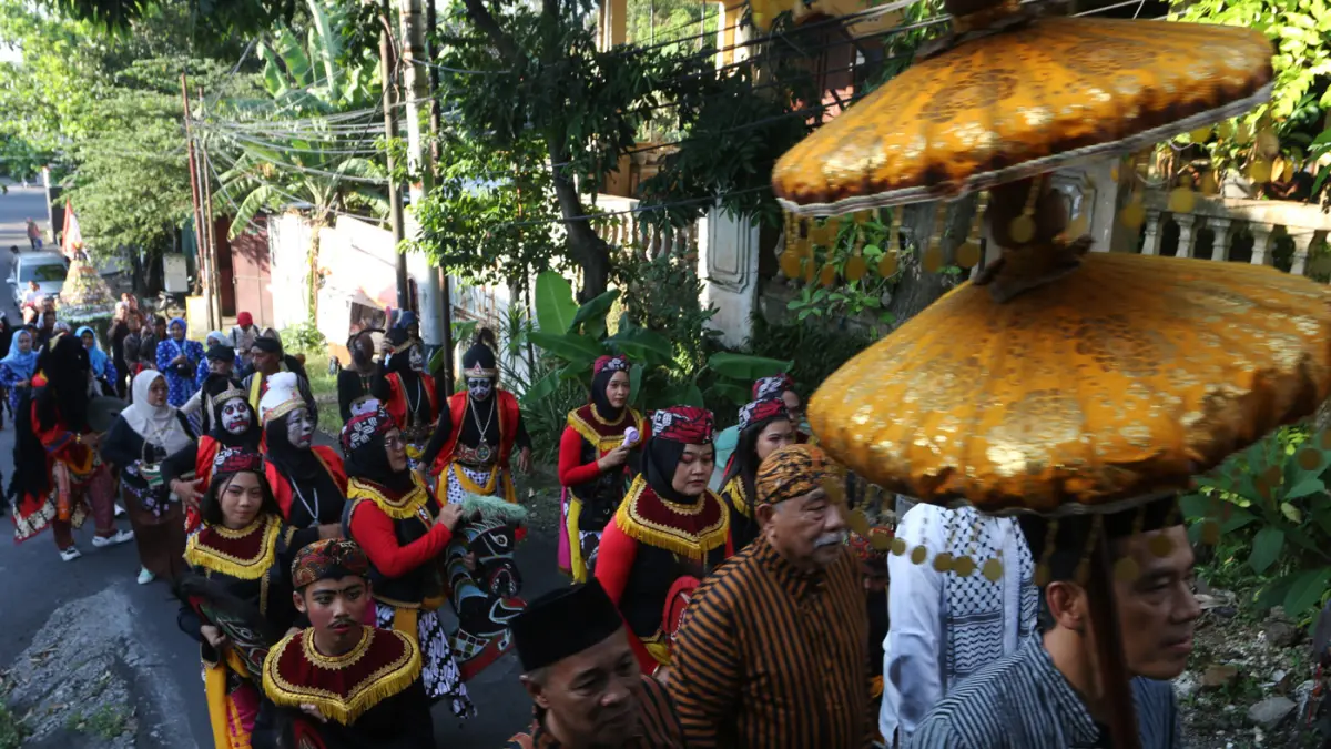 Lurah Gisikdrono Sandy Inderawan bersama istri, Damara Wibowo, mengenakan kostum pewayangan Rama dan Sinta saat memimpin kirab budaya apitan di Kelurahan Gisikdrono, Kecamatan Semarang Barat, Kamis (7/5/2026). (Nur Chamim/Jawa Pos Radar Semarang)