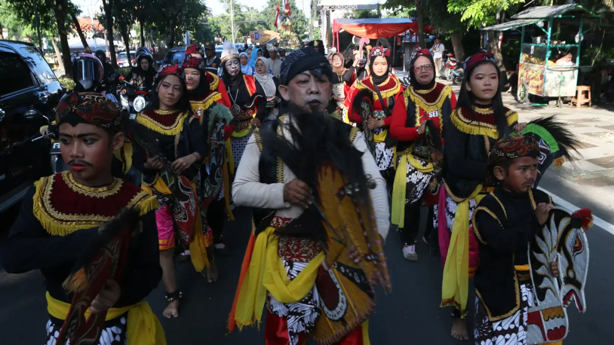 Lurah Gisikdrono Sandy Inderawan bersama istri, Damara Wibowo, mengenakan kostum pewayangan Rama dan Sinta saat memimpin kirab budaya apitan di Kelurahan Gisikdrono, Kecamatan Semarang Barat, Kamis (7/5/2026). (Nur Chamim/Jawa Pos Radar Semarang)