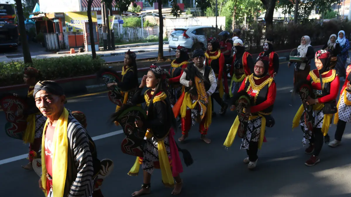 Lurah Gisikdrono Sandy Inderawan bersama istri, Damara Wibowo, mengenakan kostum pewayangan Rama dan Sinta saat memimpin kirab budaya apitan di Kelurahan Gisikdrono, Kecamatan Semarang Barat, Kamis (7/5/2026). (Nur Chamim/Jawa Pos Radar Semarang)