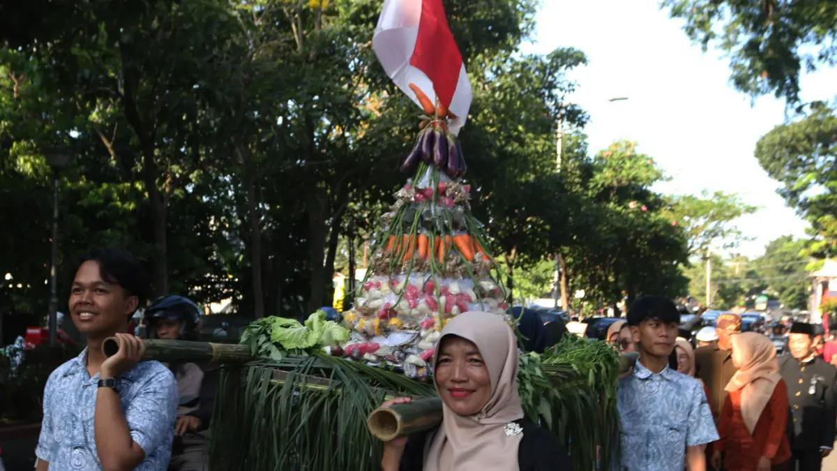 Lurah Gisikdrono Sandy Inderawan bersama istri, Damara Wibowo, mengenakan kostum pewayangan Rama dan Sinta saat memimpin kirab budaya apitan di Kelurahan Gisikdrono, Kecamatan Semarang Barat, Kamis (7/5/2026). (Nur Chamim/Jawa Pos Radar Semarang)