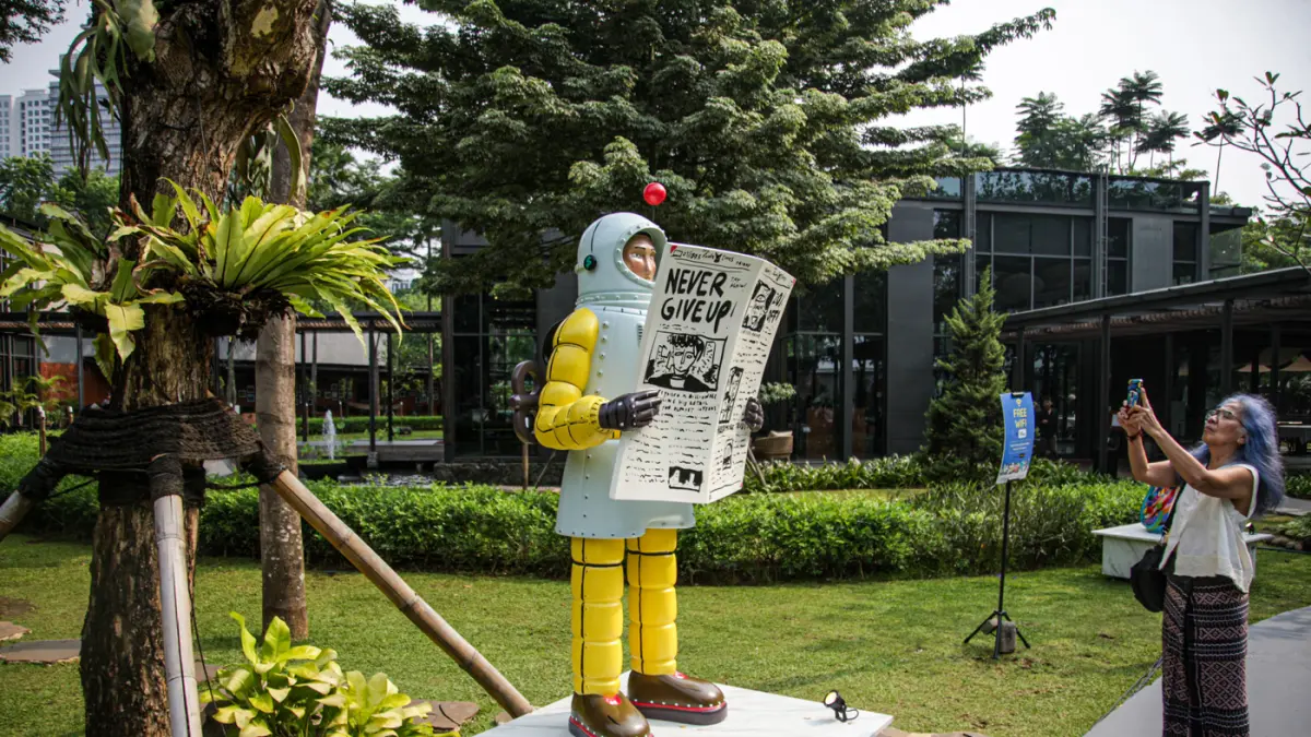 Pengunjung melihat karya Sugiri Wilim berjudul Mandi Kembang di Art Jakarta Gardens 2026, di Hutan Kota by Plataran, Jakarta, Jumat (08/05/2026). (Hanung Hambara/Jawa Pos)