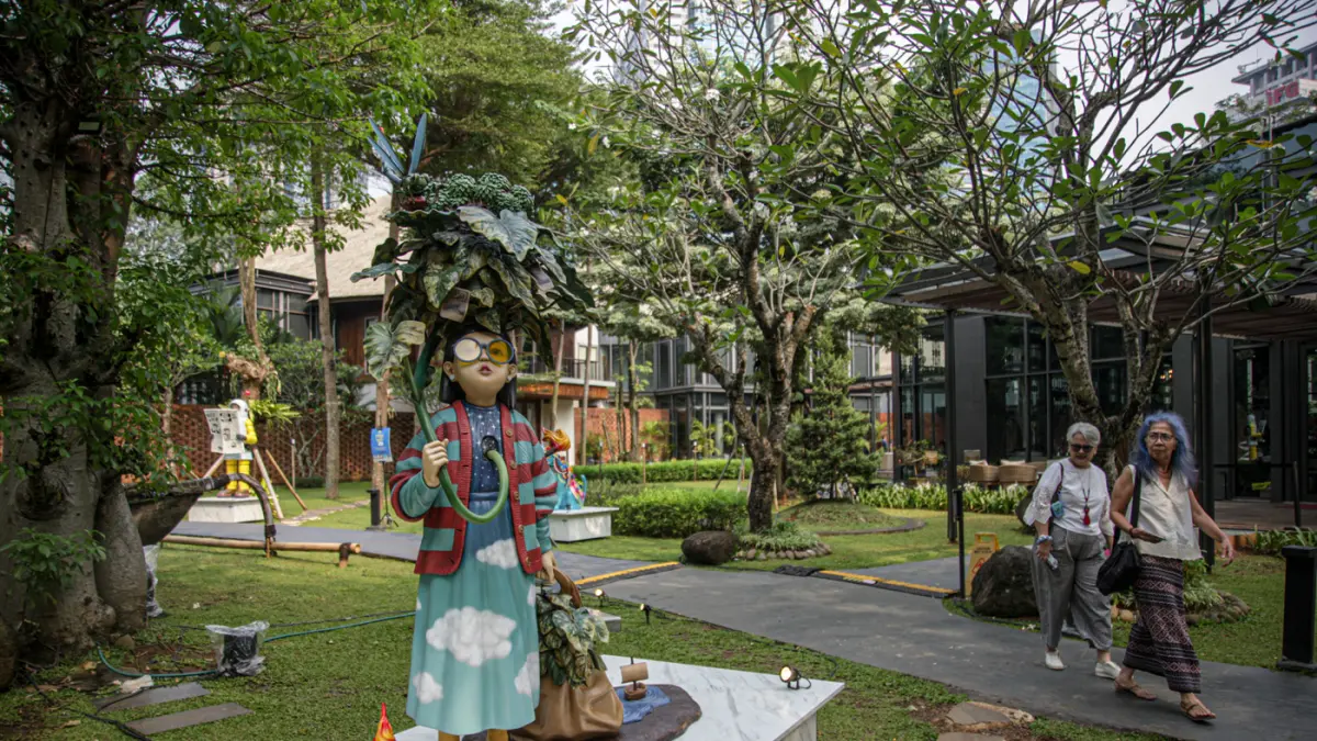 Pengunjung melihat karya Sugiri Wilim berjudul Mandi Kembang di Art Jakarta Gardens 2026, di Hutan Kota by Plataran, Jakarta, Jumat (08/05/2026). (Hanung Hambara/Jawa Pos)