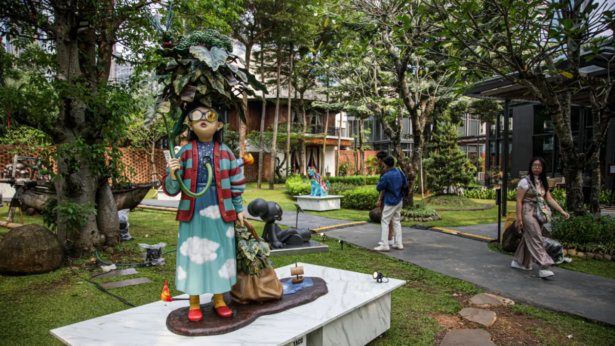 Pengunjung melihat karya Sugiri Wilim berjudul Mandi Kembang di Art Jakarta Gardens 2026, di Hutan Kota by Plataran, Jakarta, Jumat (08/05/2026). (Hanung Hambara/Jawa Pos)
