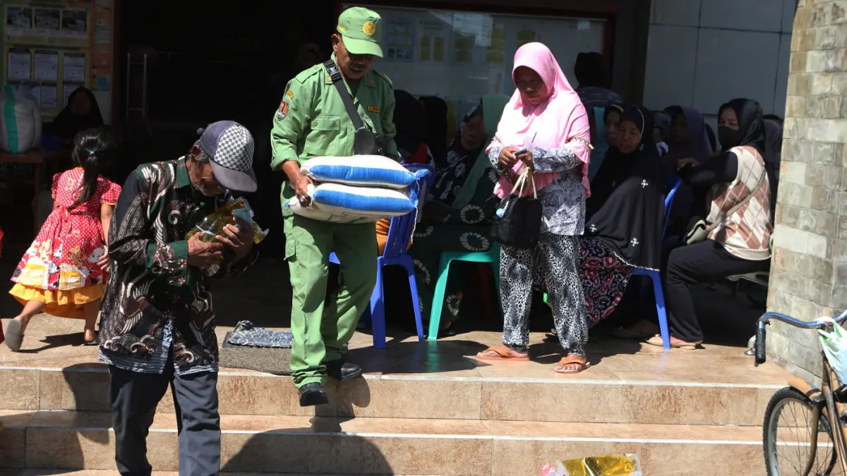 Warga Penerima Bantuan Pangan (PBP) antre untuk menerima bantuan beras dan minyak goreng di Kantor Kelurahan Gemah, Semarang, Jawa Tengah,Jumat (8/5/2026). (Nur Chamim/Jawa Pos Radar Semarang)
