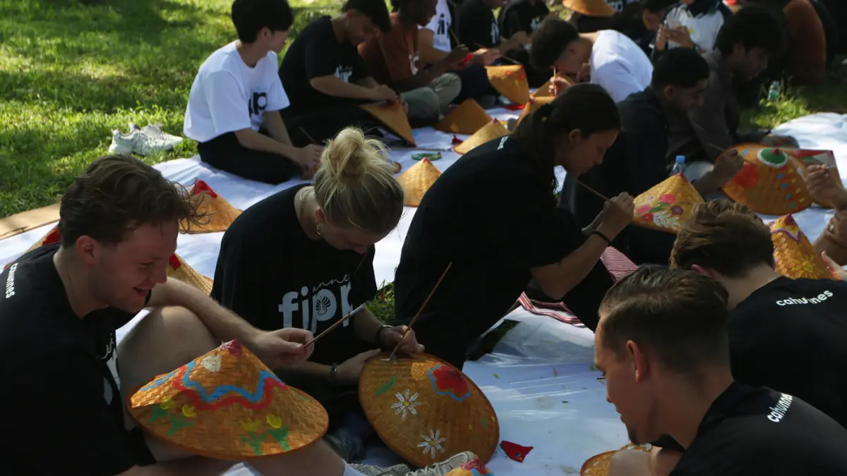 Sejumlah mahasiswa asing melukis caping pada Summer Course UNNES 2026 di desa wisata Kandri, Kota Semarang. (Nur Chamim/Jawa Pos Radar Semarang)