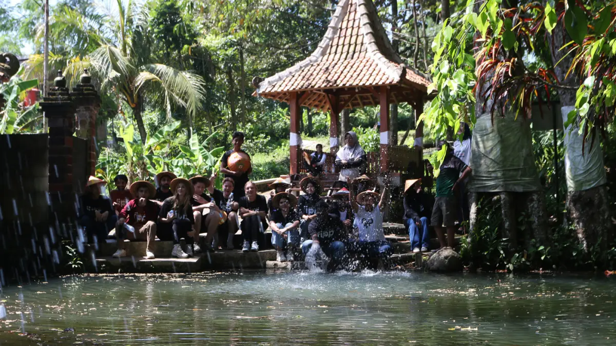 Sejumlah mahasiswa asing melukis caping pada Summer Course UNNES 2026 di desa wisata Kandri, Kota Semarang. (Nur Chamim/Jawa Pos Radar Semarang)