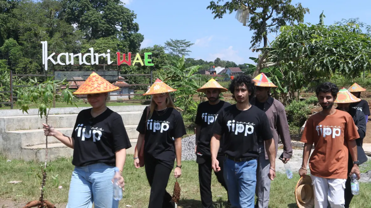 Sejumlah mahasiswa asing melukis caping pada Summer Course UNNES 2026 di desa wisata Kandri, Kota Semarang. (Nur Chamim/Jawa Pos Radar Semarang)