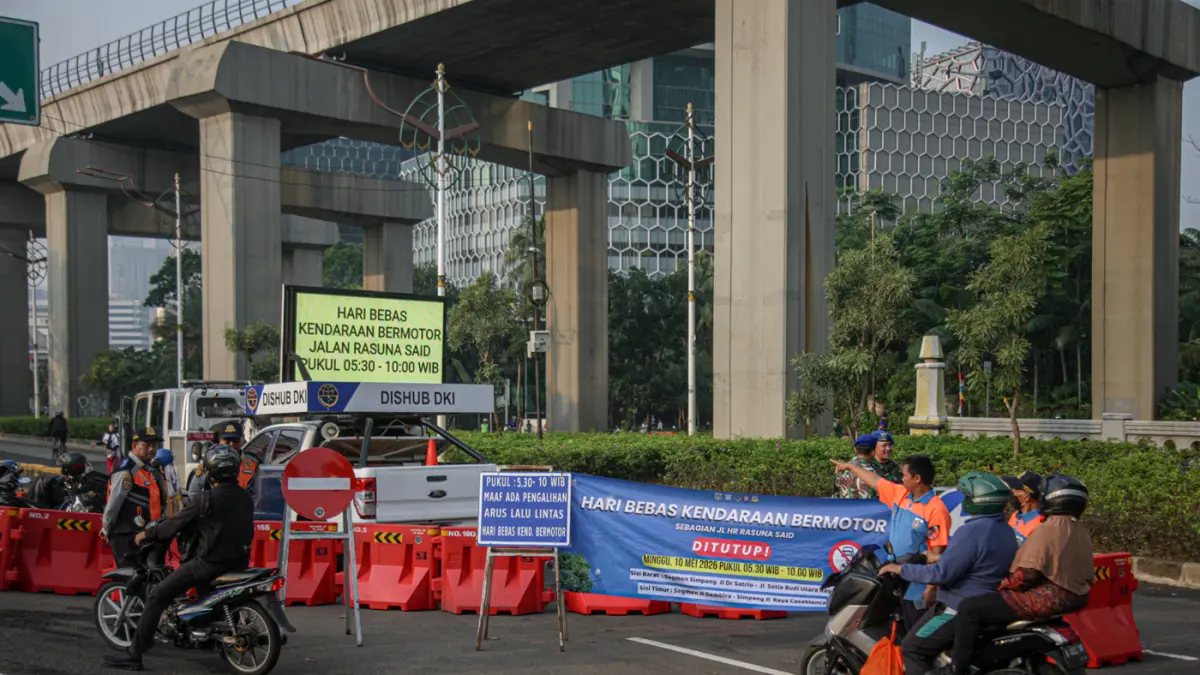 Petugas memberi himbauan saat penutupan jalan untuk HBKB di ruas jalan Rasuna Sadi, Jakarta, Minggu (10/05/2026). (Hanung Hambara/Jawa Pos)