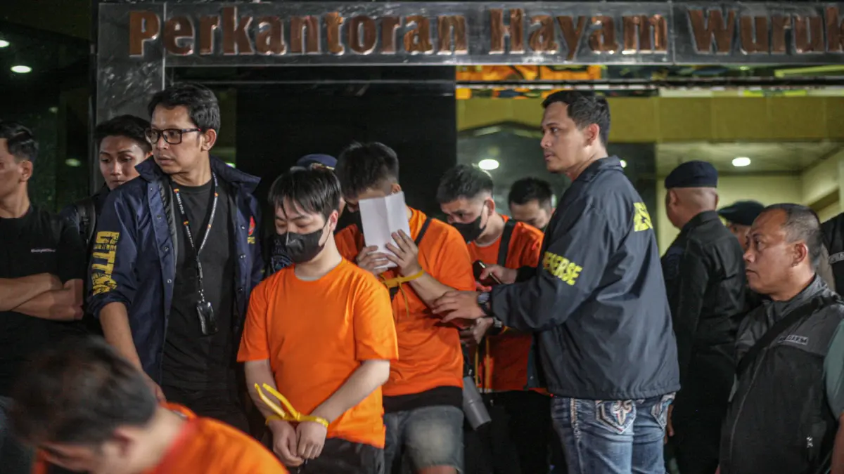 Sejumlah tersangka judi online (judol) dikawal ketat oleh aparat Kepolisian keluar dari Hayam Wuruk Tower, Jakarta, Minggu (10/05/2026). (Hanung Hambara/Jawa Pos)