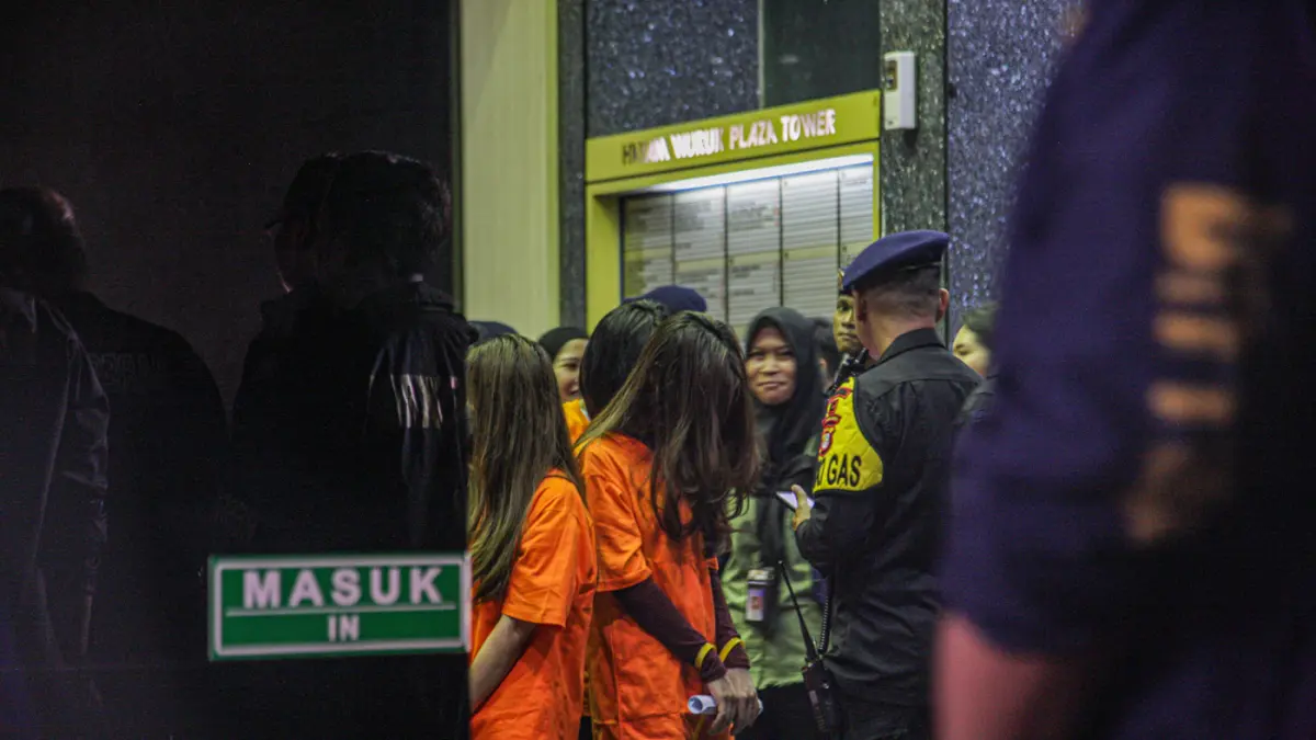 Sejumlah tersangka judi online (judol) dikawal ketat oleh aparat Kepolisian keluar dari Hayam Wuruk Tower, Jakarta, Minggu (10/05/2026). (Hanung Hambara/Jawa Pos)