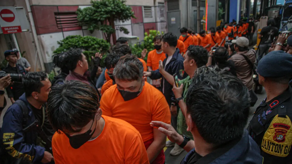 Sejumlah tersangka judi online (judol) dikawal ketat oleh aparat Kepolisian keluar dari Hayam Wuruk Tower, Jakarta, Minggu (10/05/2026). (Hanung Hambara/Jawa Pos)