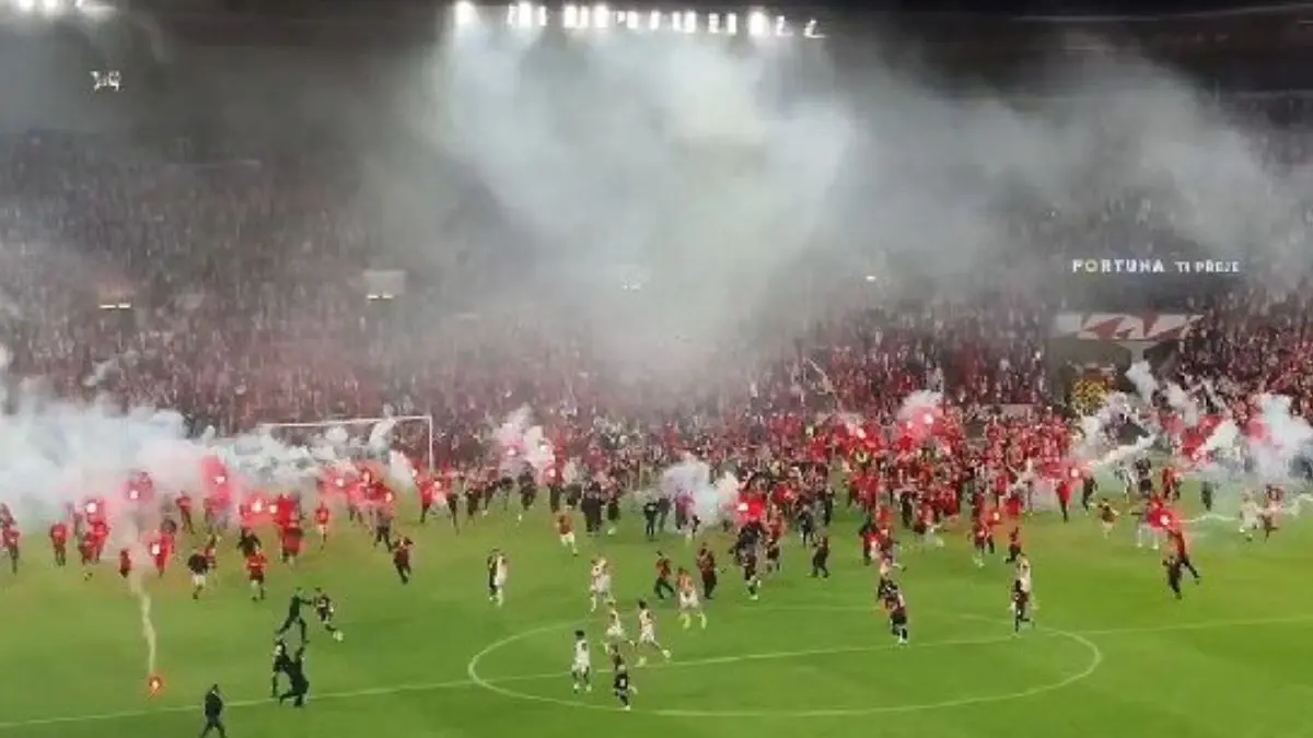 Suporter Slavia Praha menyerbu lapangan dengan membawa flare. (@KarelVltava/X) - Image