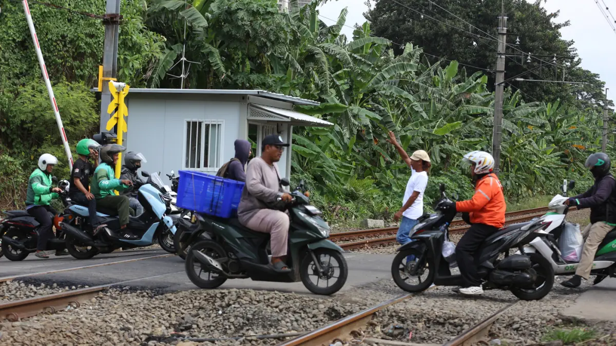 Rangkaian KRL Commuter Line melintas di Perlintasan Sebidang Kawasan Kebayoran Lama, Jakarta Selatan. (Dery Ridwansah/ JawaPos.com)