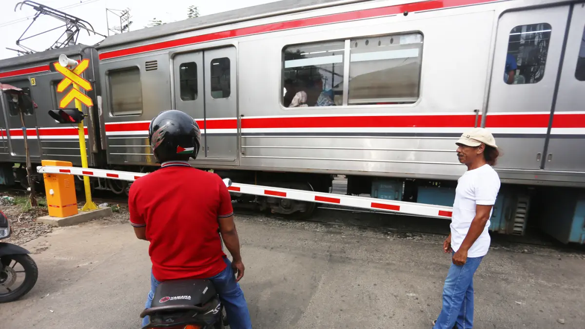 Rangkaian KRL Commuter Line melintas di Perlintasan Sebidang Kawasan Kebayoran Lama, Jakarta Selatan. (Dery Ridwansah/ JawaPos.com)