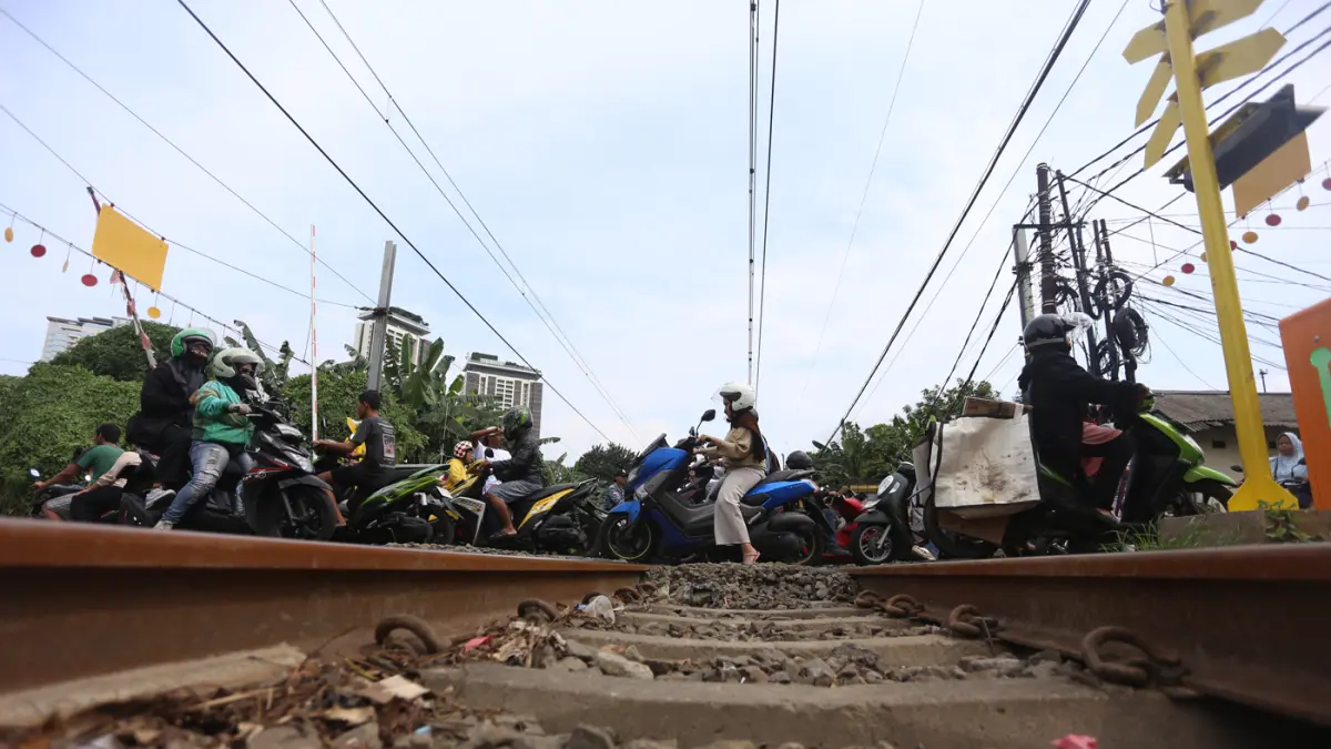 Rangkaian KRL Commuter Line melintas di Perlintasan Sebidang Kawasan Kebayoran Lama, Jakarta Selatan. (Dery Ridwansah/ JawaPos.com)