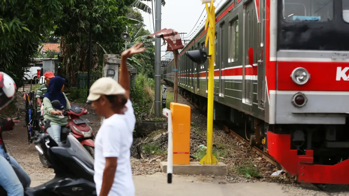 Rangkaian KRL Commuter Line melintas di Perlintasan Sebidang Kawasan Kebayoran Lama, Jakarta Selatan. (Dery Ridwansah/ JawaPos.com)