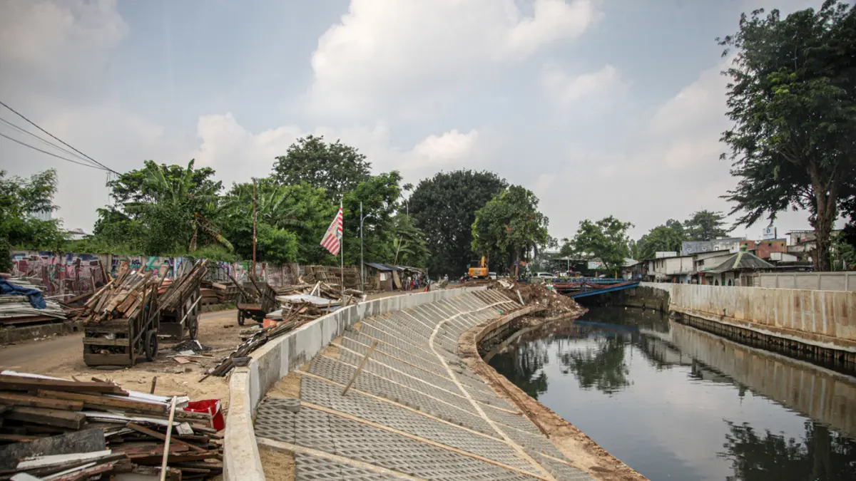 Sejumlah pekerja melakukan pemasangan paving blok di sepadan aliran Kali Grogol, Jakarta, (11/05/2026). (Hanung Hambara/Jawa Pos)