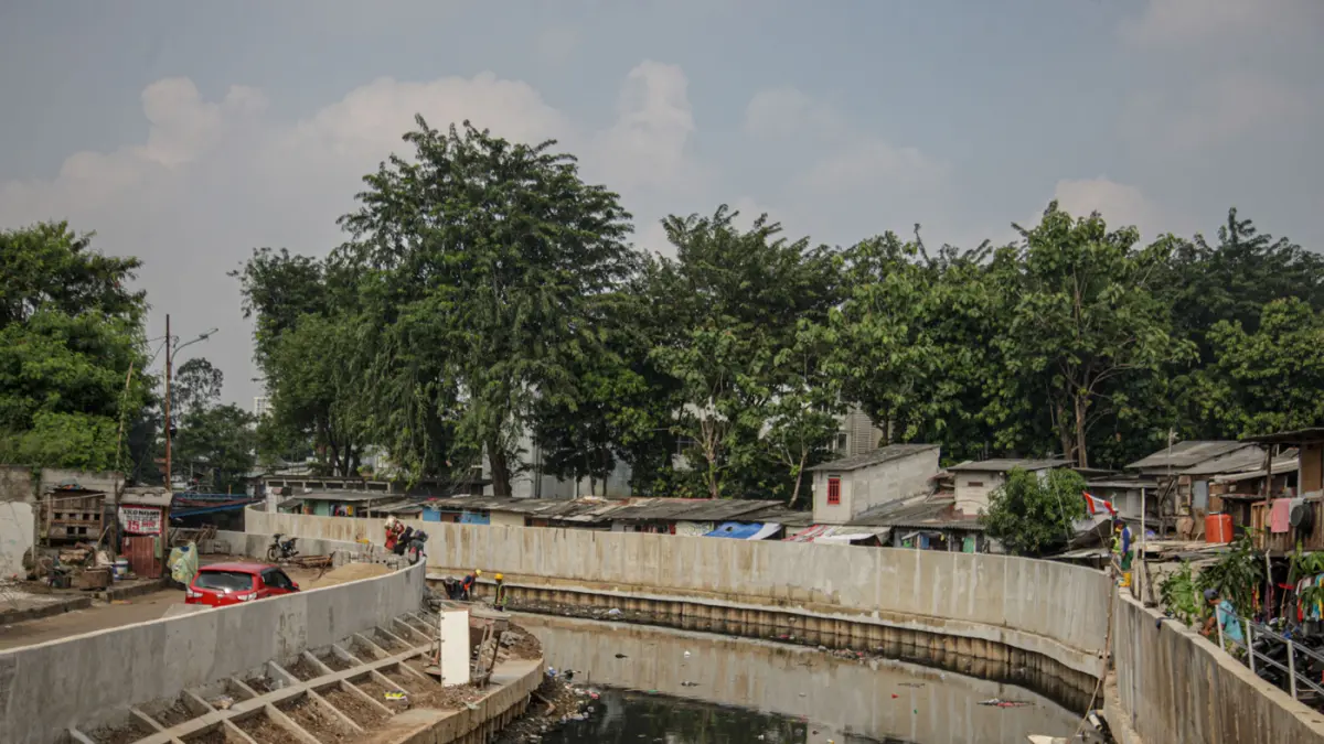 Sejumlah pekerja melakukan pemasangan paving blok di sepadan aliran Kali Grogol, Jakarta, (11/05/2026). (Hanung Hambara/Jawa Pos)