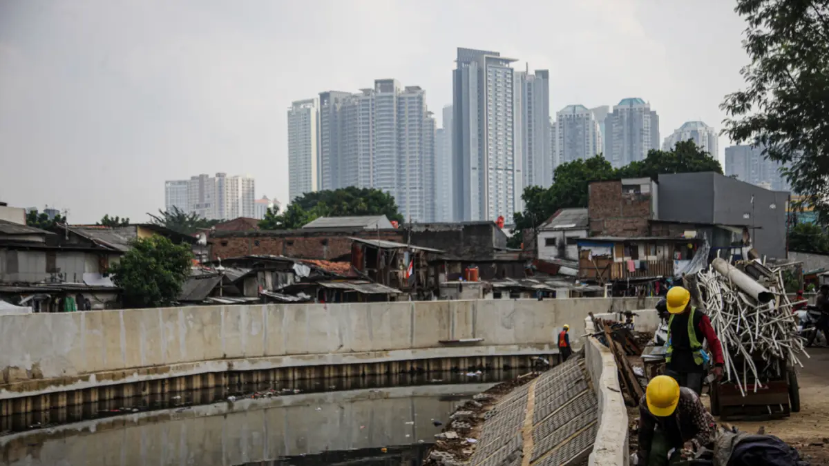 Sejumlah pekerja melakukan pemasangan paving blok di sepadan aliran Kali Grogol, Jakarta, (11/05/2026). (Hanung Hambara/Jawa Pos)