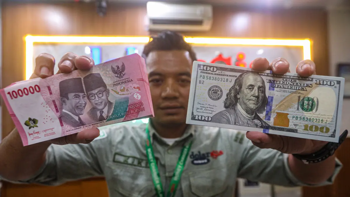 Karyawan menunjukan uang pecahan rupiah dan dolar Amerika Serikat (AS) di gerai penukaran mata uang asing Dolar Asia, Jakarta, Selasa (12/5/2026). (Salman Toyibi/Jawa Pos)
