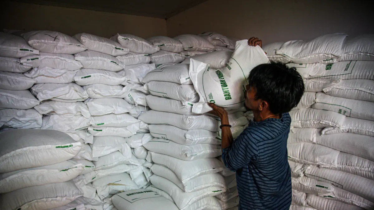 Warga penerima bantuan pangan membawa sejumlah bantuan berupa beras dan minyak goreng saat penyaluran bantuan Keluarga Penerima Manfaat (KPM) di Kantor Kelurahan Batusari, Kota Tangerang, Kamis (14/5/2026). (Hanung Hambara/Jawa Pos)