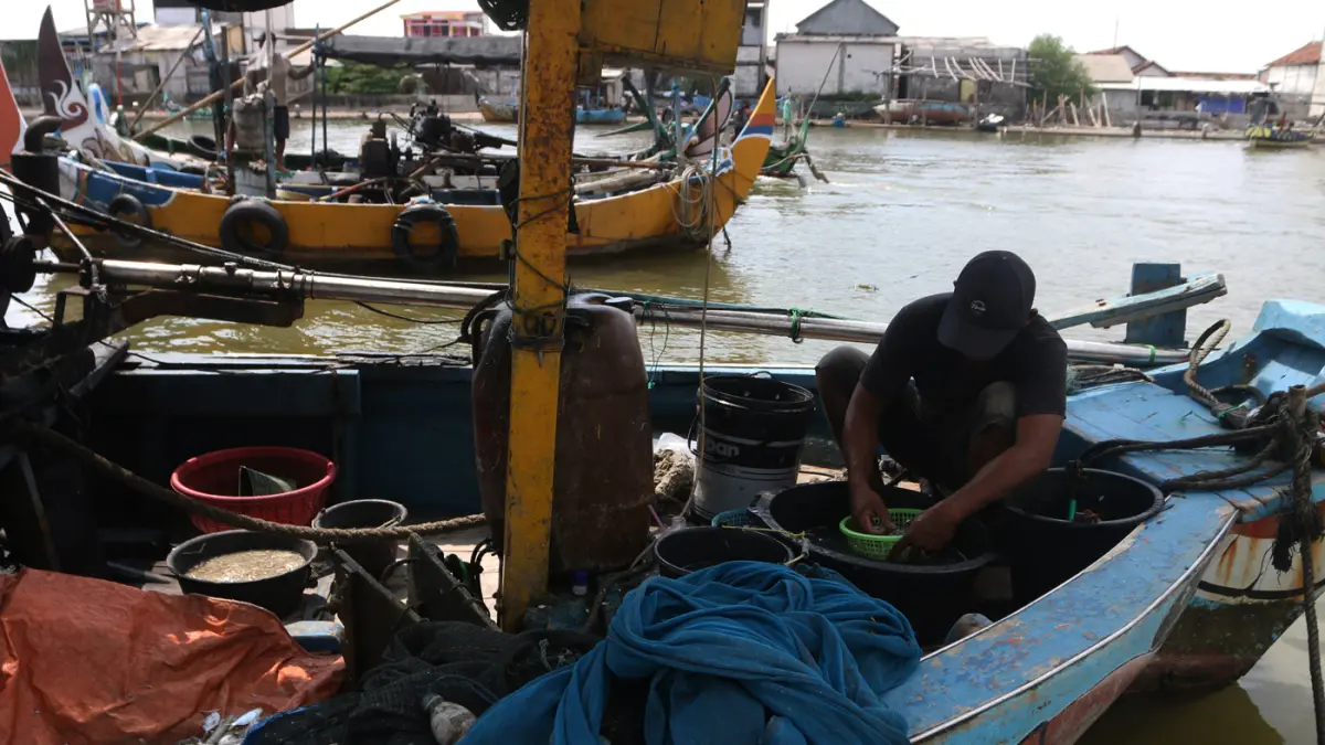 Nelayan memperbaiki perahu di dermaga Tambaklorok, Semarang, Kamis (21/5/2026). (Nur Chamim/Jawa Pos Radar Semarang)