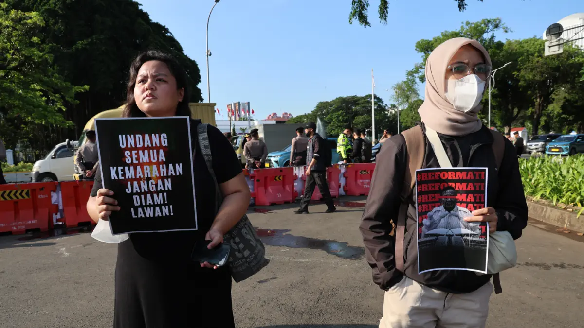 Pegiat HAM yang tergabung dalam Jaringan Solidaritas Korban untuk Keadilan menaburkan bunga saat aksi kamisan ke-908 di seberang Istana Merdeka, Jakarta, Kamis (21/5/2026). (Dery Ridwansah/ JawaPos.com)