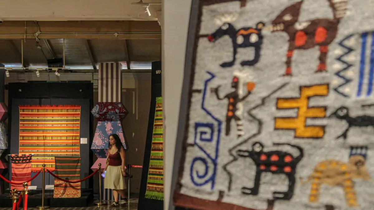 Pengunjung melihat perpaduan koleksi kain tenun dari Ekuador dan Nusa Tenggara (Indonesia) di pameran Menenun Warna Tanpa Batas Indonesia dan Ekuador di Museum Tekstil, Jakarta, Minggu (17/05/2026). (Hanung Hambara/Jawa Pos)