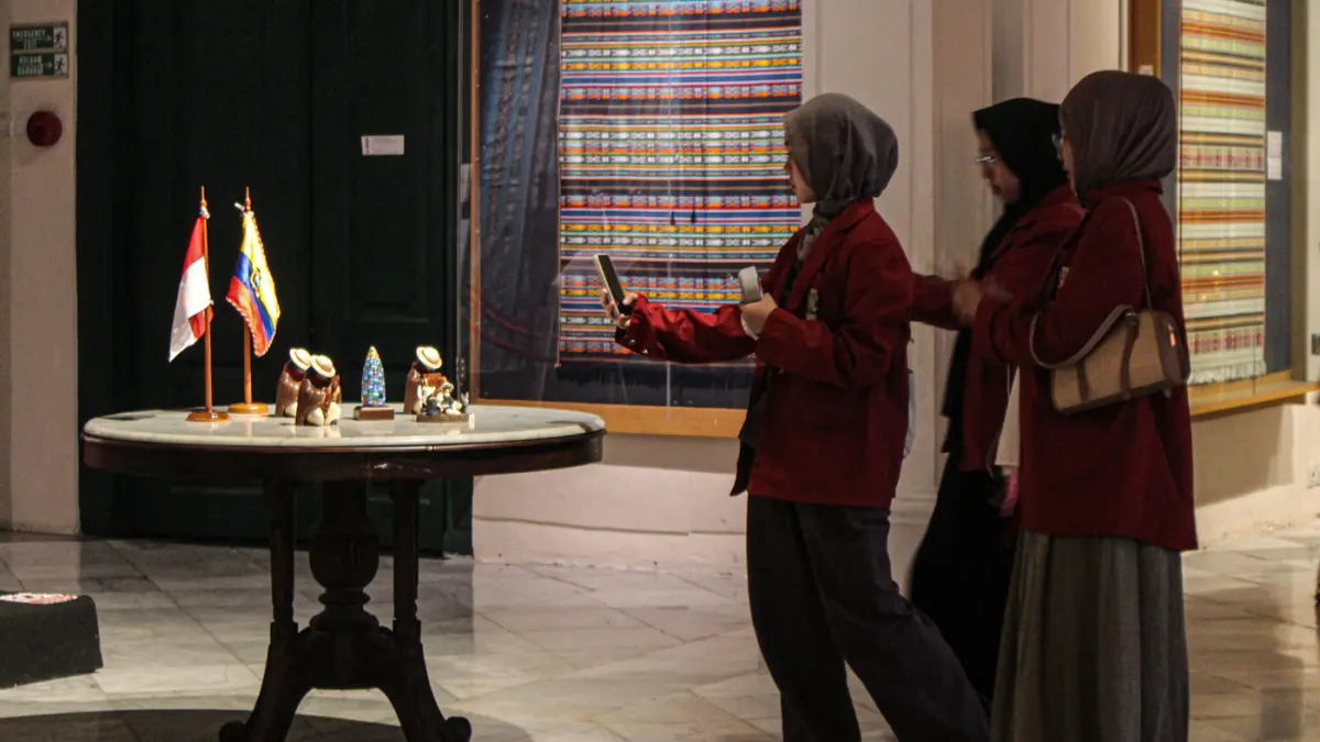 Pengunjung melihat perpaduan koleksi kain tenun dari Ekuador dan Nusa Tenggara (Indonesia) di pameran Menenun Warna Tanpa Batas Indonesia dan Ekuador di Museum Tekstil, Jakarta, Minggu (17/05/2026). (Hanung Hambara/Jawa Pos)