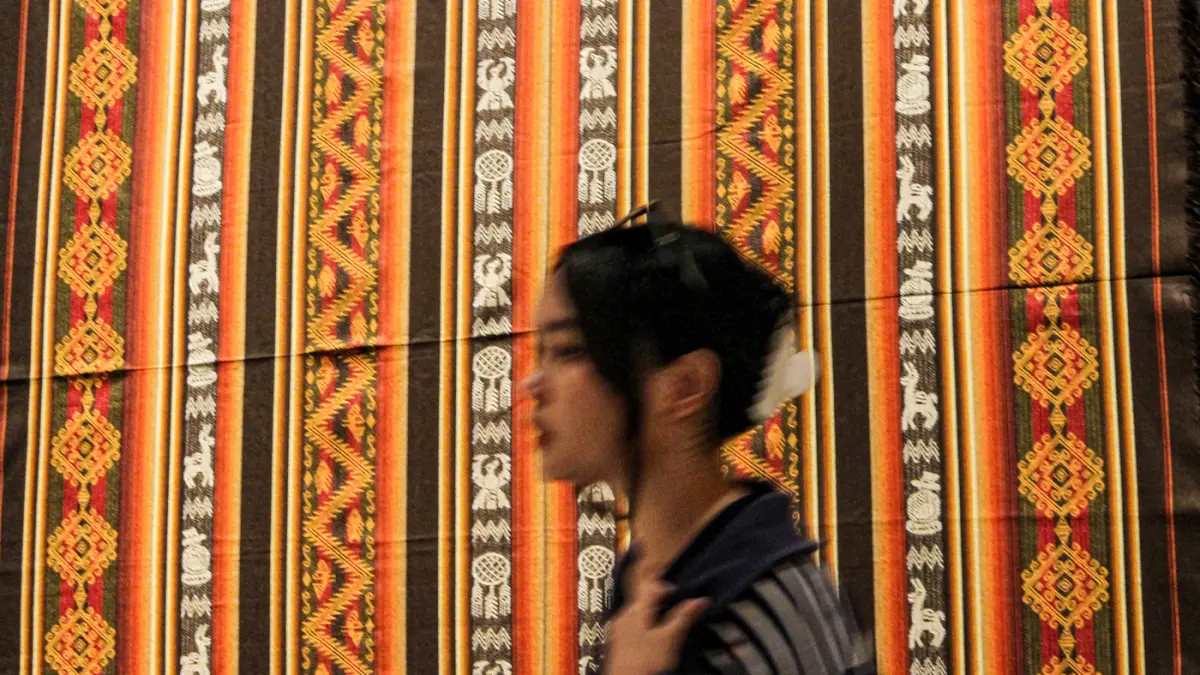 Pengunjung melihat perpaduan koleksi kain tenun dari Ekuador dan Nusa Tenggara (Indonesia) di pameran Menenun Warna Tanpa Batas Indonesia dan Ekuador di Museum Tekstil, Jakarta, Minggu (17/05/2026). (Hanung Hambara/Jawa Pos)