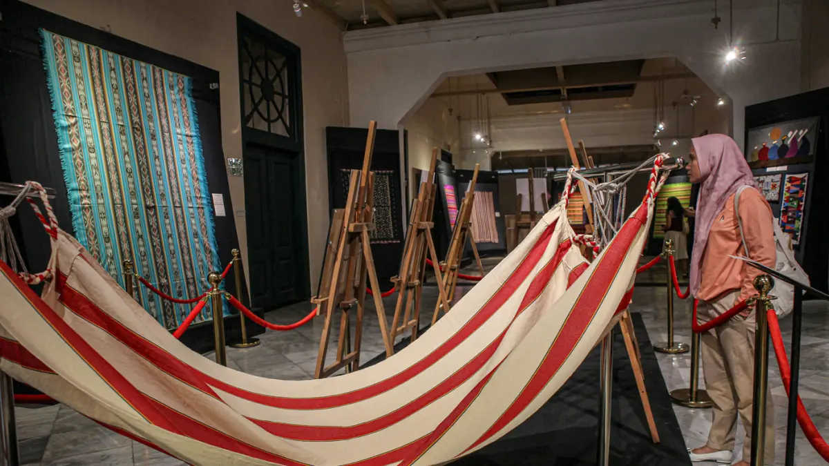 Pengunjung melihat perpaduan koleksi kain tenun dari Ekuador dan Nusa Tenggara (Indonesia) di pameran Menenun Warna Tanpa Batas Indonesia dan Ekuador di Museum Tekstil, Jakarta, Minggu (17/05/2026). (Hanung Hambara/Jawa Pos)
