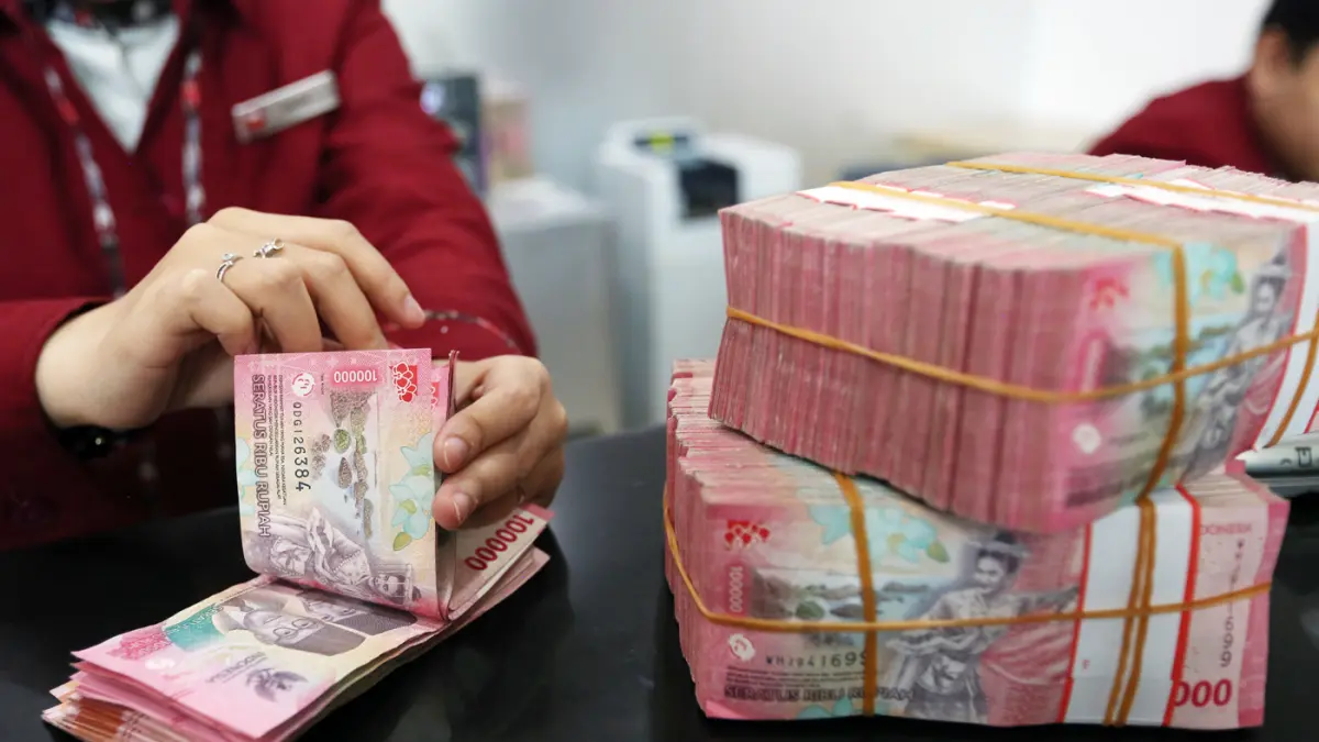 Karyawan menunjukkan uang pecahan rupiah dan dolar Amerika Serikat (AS) di gerai penukaran mata uang asing di Jakarta. (Dery Ridwansah/ JawaPos.com)