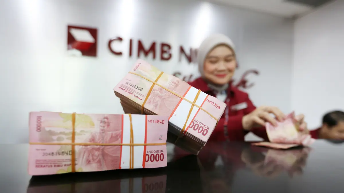 Karyawan menunjukkan uang pecahan rupiah dan dolar Amerika Serikat (AS) di gerai penukaran mata uang asing di Jakarta. (Dery Ridwansah/ JawaPos.com)
